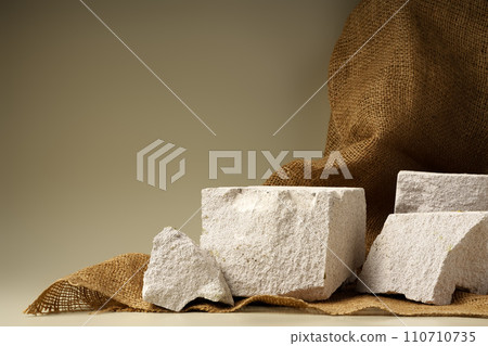 Granite stone podium decorated with sackcloth on beige background Granite stone podium decorated with sackcloth on beige background 110710735