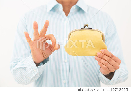 一名中年婦女拿著錢包並做圓圈標誌 110712935