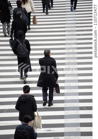 People crossing a crosswalk at an intersection in a winter city People crossing a crosswalk at an intersection in a winter city 110713477