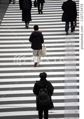 People crossing a crosswalk at an intersection in a winter city 110713478