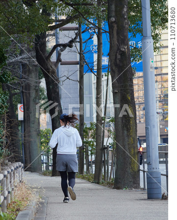 Runners running on the path of the Imperial Palace Gaien in Tokyo in winter 110713680