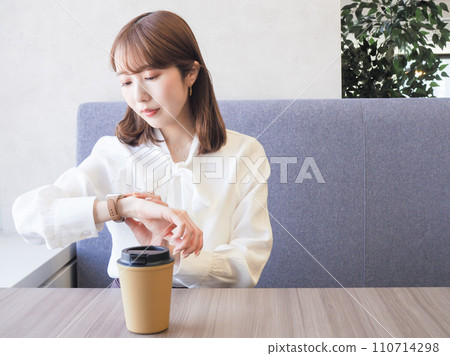 一位女士在咖啡館看著手錶 110714298