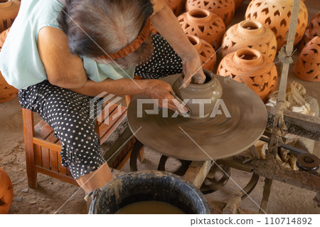 Earthenware earthen pot or a clay pot bowl. Traditional old local woman. People lifestyle. Earthenware earthen pot or a clay pot bowl. Traditional old local woman. People lifestyle. 110714892