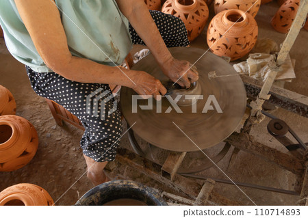Earthenware earthen pot or a clay pot bowl. Traditional old local woman. People lifestyle. Earthenware earthen pot or a clay pot bowl. Traditional old local woman. People lifestyle. 110714893
