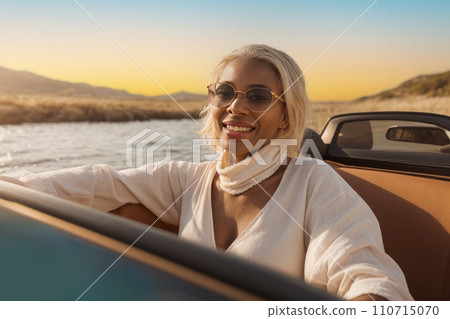 Young Woman with is happy and enjoys ride in cabrio car along coast sea. active, confident and happy woman Young Woman with is happy and enjoys ride in cabrio car along coast sea. active, confident and happy woman 110715070
