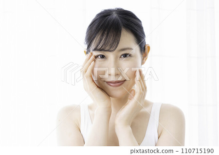 A woman in her 30s feels the moisture in her skin A woman in her 30s feels the moisture in her skin 110715190