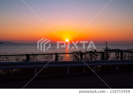 The sun setting on the horizon 110715459