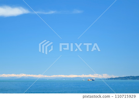 Natural blue background with snowy mountains on sea coast and ships port. Natural blue background with snowy mountains on sea coast and ships port. 110715929