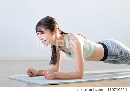 A woman training her core with a plank 110716224