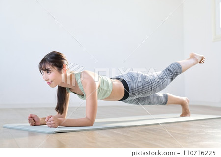 一位女士用單腳抬起的木板訓練她的核心 110716225