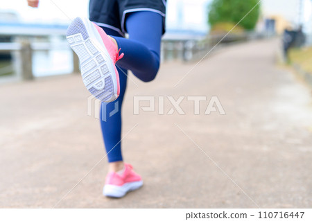 Feet of a young woman jogging outside along the river, diet running wear 110716447