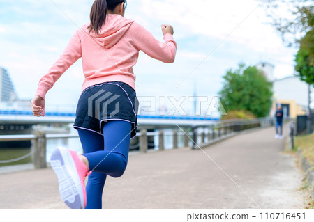 Feet of a young woman jogging outside along the river, diet running wear Feet of a young woman jogging outside along the river, diet running wear 110716451