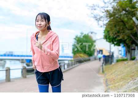 Feet of a young woman jogging outside along the river, diet running wear Feet of a young woman jogging outside along the river, diet running wear 110717308