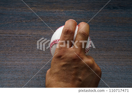Man's hand holding a hardball baseball ball Man's hand holding a hardball baseball ball 110717471