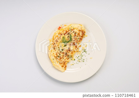 Breakfast. Omelet with vegetables and cheese on a white plate and a white background. Breakfast. Omelet with vegetables and cheese on a white plate and a white background. 110718461