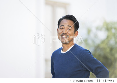 A man in his mid-50s smiling at the camera 110718664