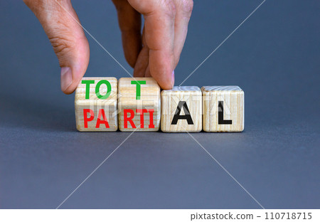 Total or partial symbol. Businessman turns beautiful wooden cubes and changes the word Partial to Total. Beautiful grey table grey background. Business and total or partial concept. Copy space. Total or partial symbol. Businessman turns beautiful wooden cubes and changes the word Partial to Total. Beautiful grey table grey background. Business and total or partial concept. Copy space. 110718715