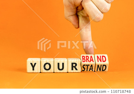 Branding your brand or stand symbol. Concept words Your stand Your brand on beautiful blocks. Beautiful orange background. Businessman hand. Business branding your brand or stand concept. Copy space. 110718748