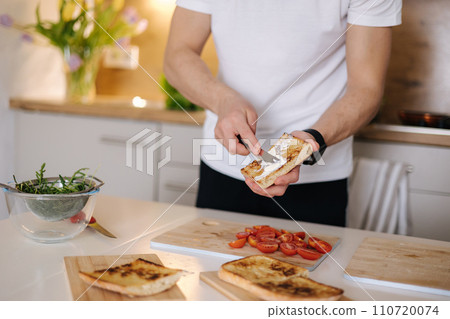 Middle selection of man spread vegan cream cheese on baguette. Home made sandwich 110720074