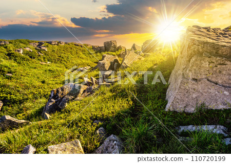 mountain summer landscape at sunset. meadow with huge stones among the grass on top of the hillside. beautiful countryside scenery in evening light mountain summer landscape at sunset. meadow with huge stones among the grass on top of the hillside. beautiful countryside scenery in evening light 110720199