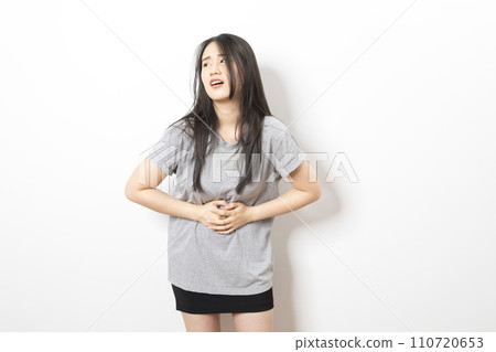 Young asian woman have stomach ache with uneasy face 110720653