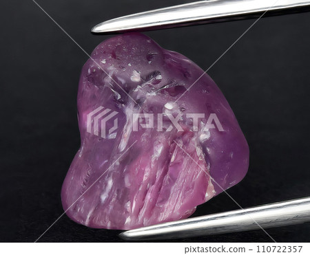 natural purple sapphire rough gem on the background 110722357