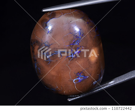 natural rainbow boulder opal gem on the background 110722442