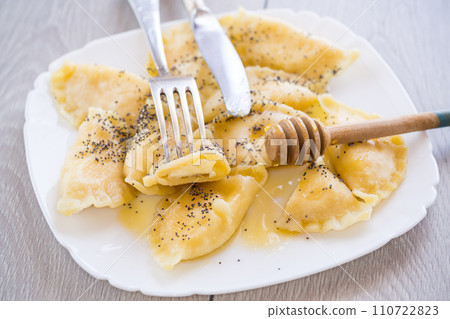 sweet cooked dumplings with cottage cheese, poppy seeds and honey. sweet cooked dumplings with cottage cheese, poppy seeds and honey. 110722823