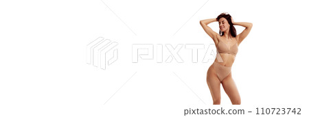 Banner. beautiful and fit woman in beige lingerie against white studio background with negative space to insert text. Banner. beautiful and fit woman in beige lingerie against white studio background with negative space to insert text. 110723742