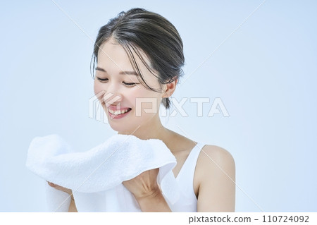 A woman wiping his face with a towel 110724092