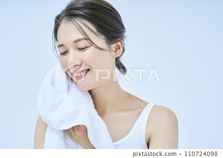 A woman wiping his face with a towel 110724098