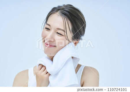 A woman wiping his face with a towel 110724101