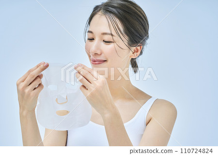 A woman doing skin care using a face pack 110724824