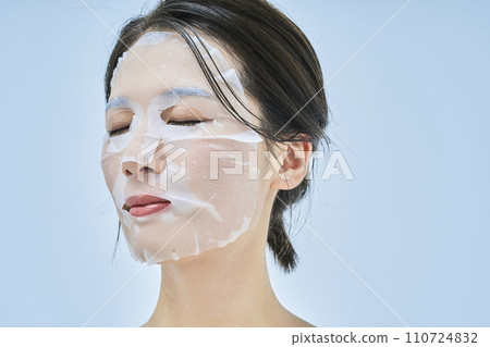 A woman doing skin care using a face pack 110724832