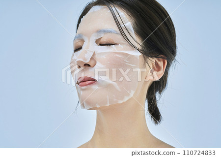 A woman doing skin care using a face pack A woman doing skin care using a face pack 110724833