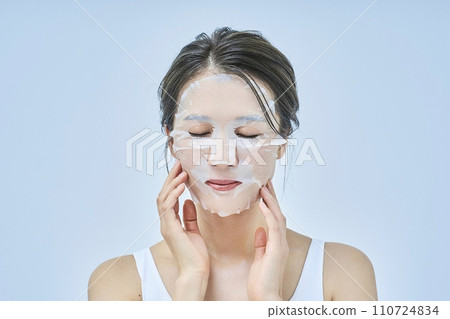 A woman doing skin care using a face pack 110724834