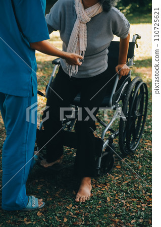 young asian physical therapist working with senior woman on walking with a walker 110725621