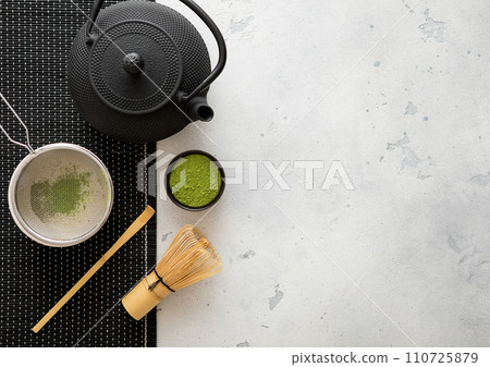 Japanese iron kettle with matcha green tea powder with whisk and spoon and bowl with sifter 110725879