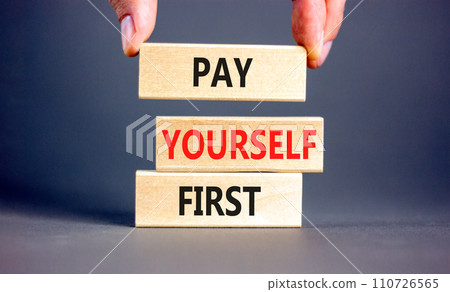 Pay yourself first symbol. Concept words Pay yourself first on beautiful wooden blocks. Beautiful grey table grey background. Businessman hand. Business and pay yourself first concept. Copy space. Pay yourself first symbol. Concept words Pay yourself first on beautiful wooden blocks. Beautiful grey table grey background. Businessman hand. Business and pay yourself first concept. Copy space. 110726565