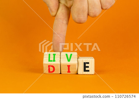 Live or die symbol. Concept word Live or Die on wooden cubes. Beautiful orange table orange background. Businessman hand. Business lifestyle and live or die concept. Copy space. Live or die symbol. Concept word Live or Die on wooden cubes. Beautiful orange table orange background. Businessman hand. Business lifestyle and live or die concept. Copy space. 110726574