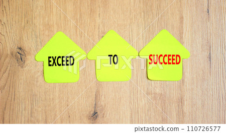 Exceed to succeed symbol. Concept words Exceed to succeed on beautiful yellow paper houses. Beautiful wooden table wooden background. Business and exceed to succeed concept. Copy space. 110726577