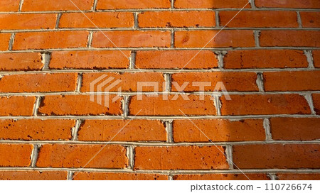 banner with background of red sunny brick wall with empty copy space, brickwork fragment of part of building, graphic texture for design and industry, masonry of orange bricks 110726674