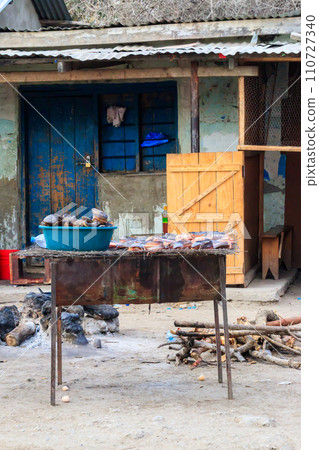 Fish cooking for sale at a local street food market in Tanzania 110727340
