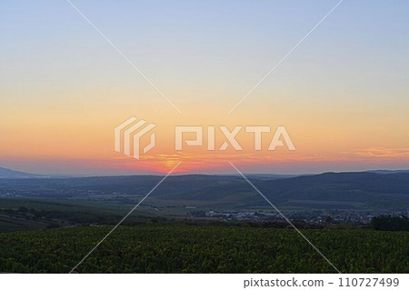 Romantic sunset with the blush of dawn. Twilight with red sky over the landscape. Enchanting sunset with red clouds 110727499