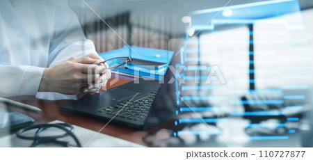 Doctor holding glasses at table in office. Doctor holding glasses at table in office. 110727877