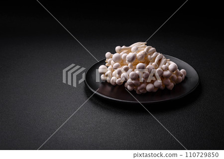 Small white edible beech mushrooms with salt and spices on a plain background Small white edible beech mushrooms with salt and spices on a plain background 110729850