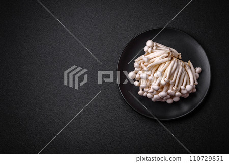 Small white edible beech mushrooms with salt and spices on a plain background Small white edible beech mushrooms with salt and spices on a plain background 110729851