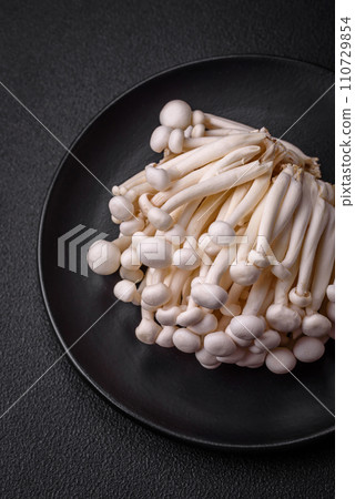 Small white edible beech mushrooms with salt and spices on a plain background 110729854