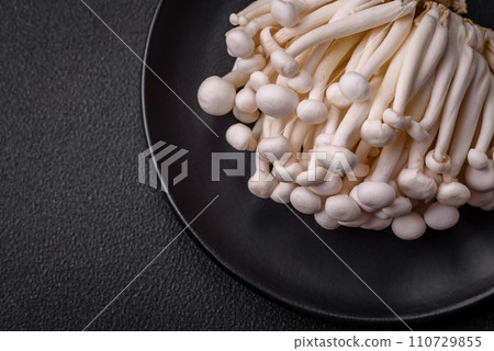 Small white edible beech mushrooms with salt and spices on a plain background 110729855