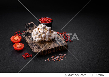Small white edible beech mushrooms with salt and spices on a plain background 110729870